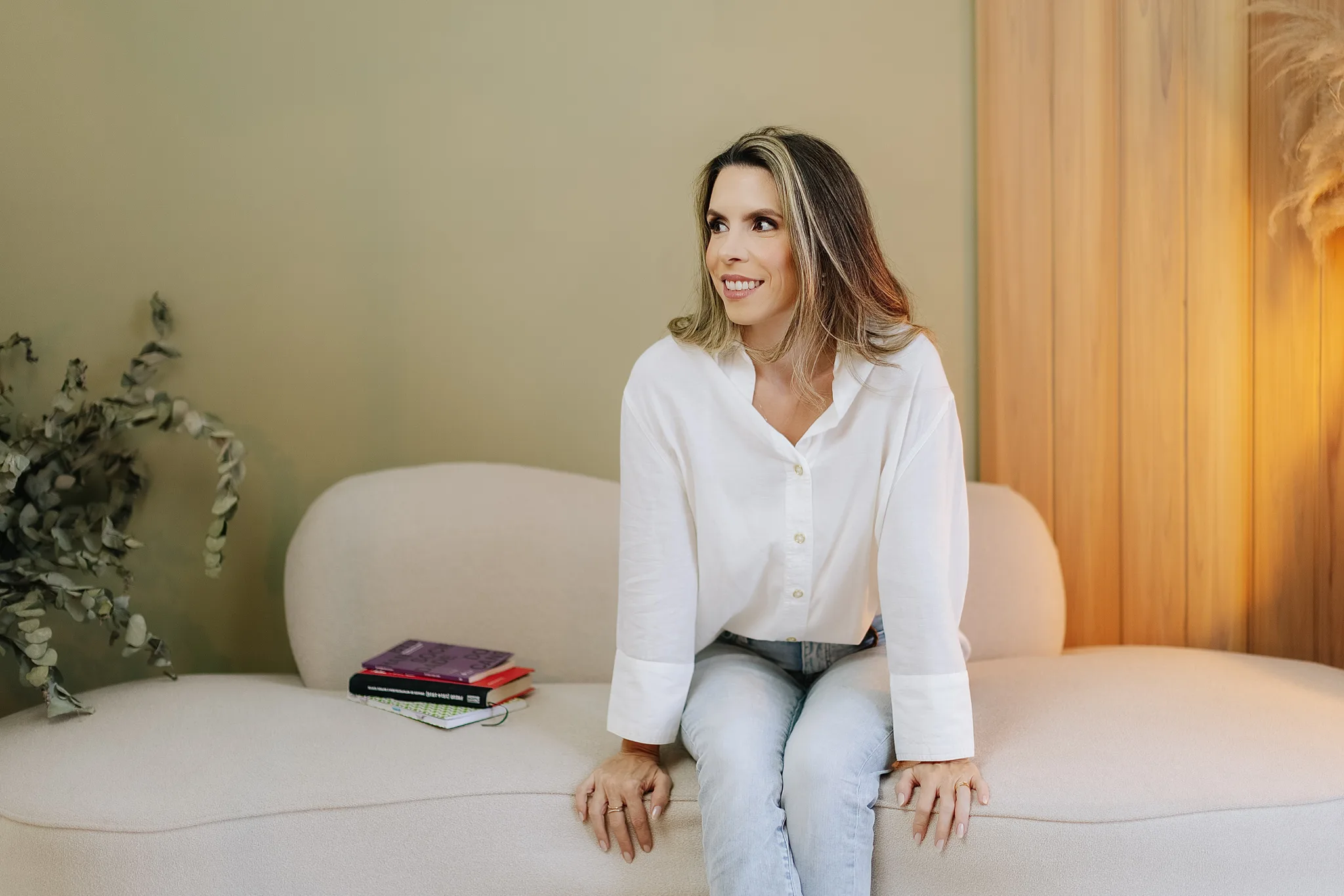 Mirela Esteves sentada no sofá do consultório